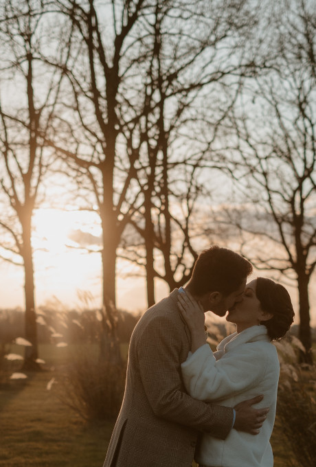 mariés qui s'embrassent près des grands chênes en hiver